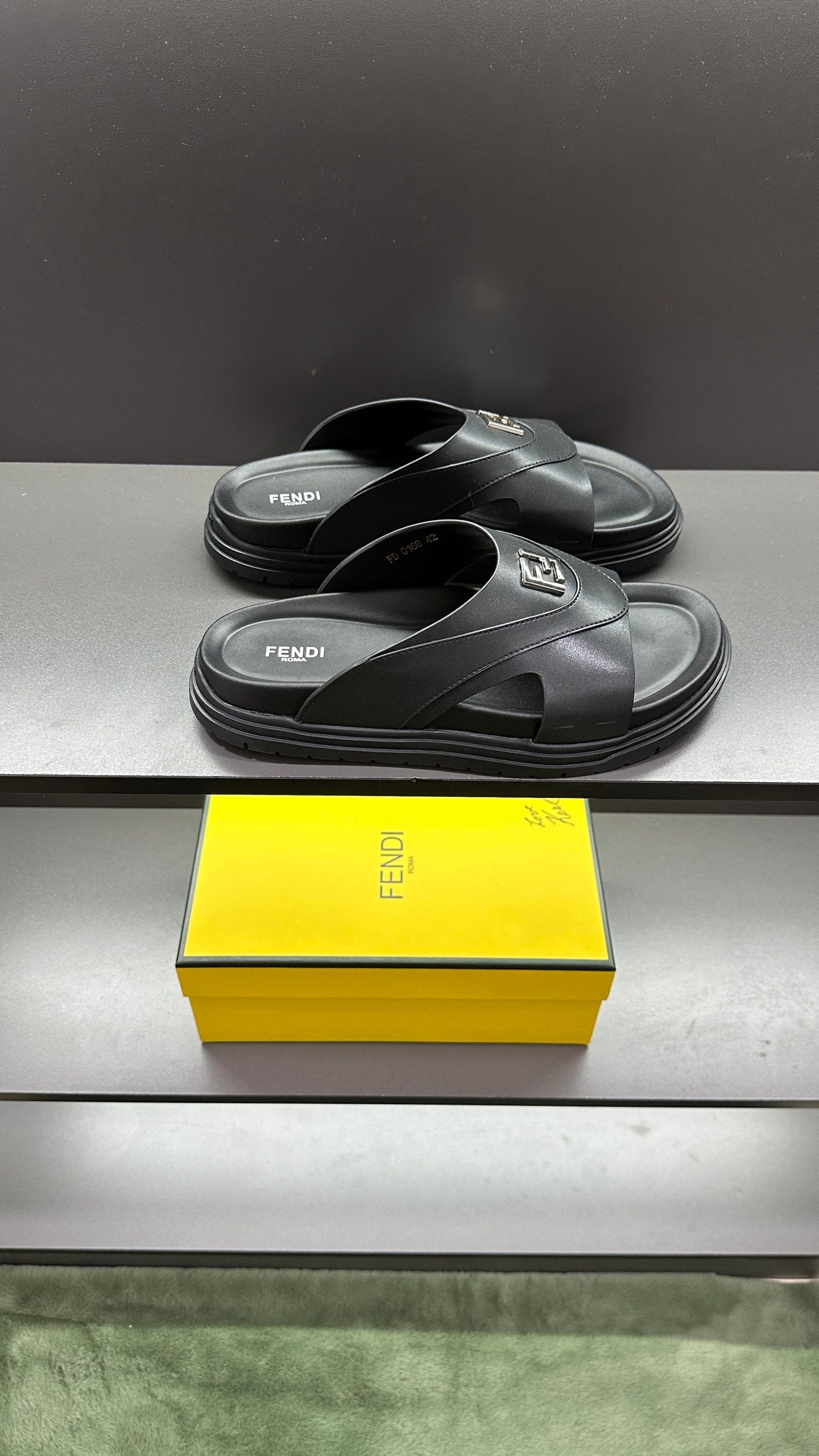 Fendi slide sandals with dark leather straps and open toe on curved, chunky sole