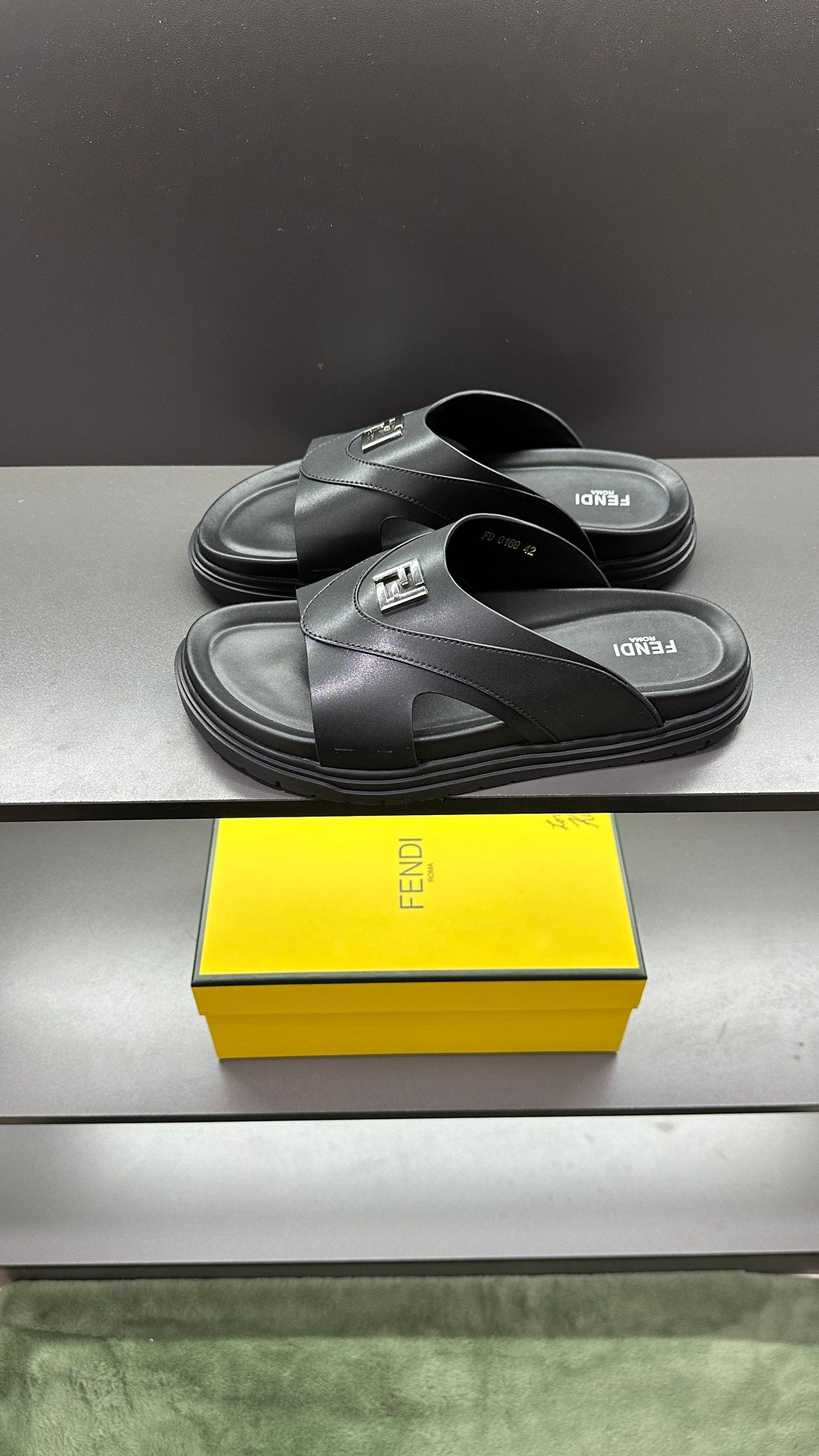 Fendi dark slide sandals with wide strap and logo detail, stacked pair view