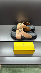 Fendi beige slide sandals with wide strap and black trim, shown from side angle