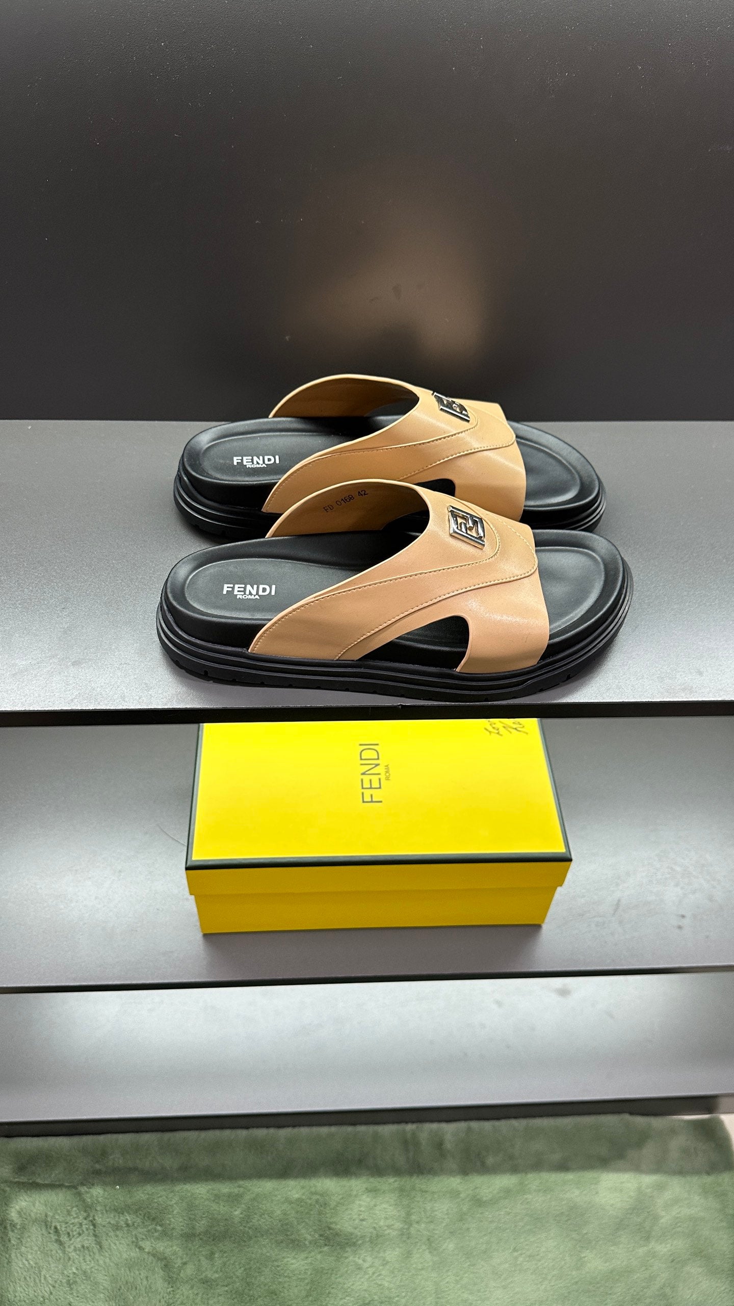 Pair of Fendi beige slide sandals stacked on black soles, with F logo on strap