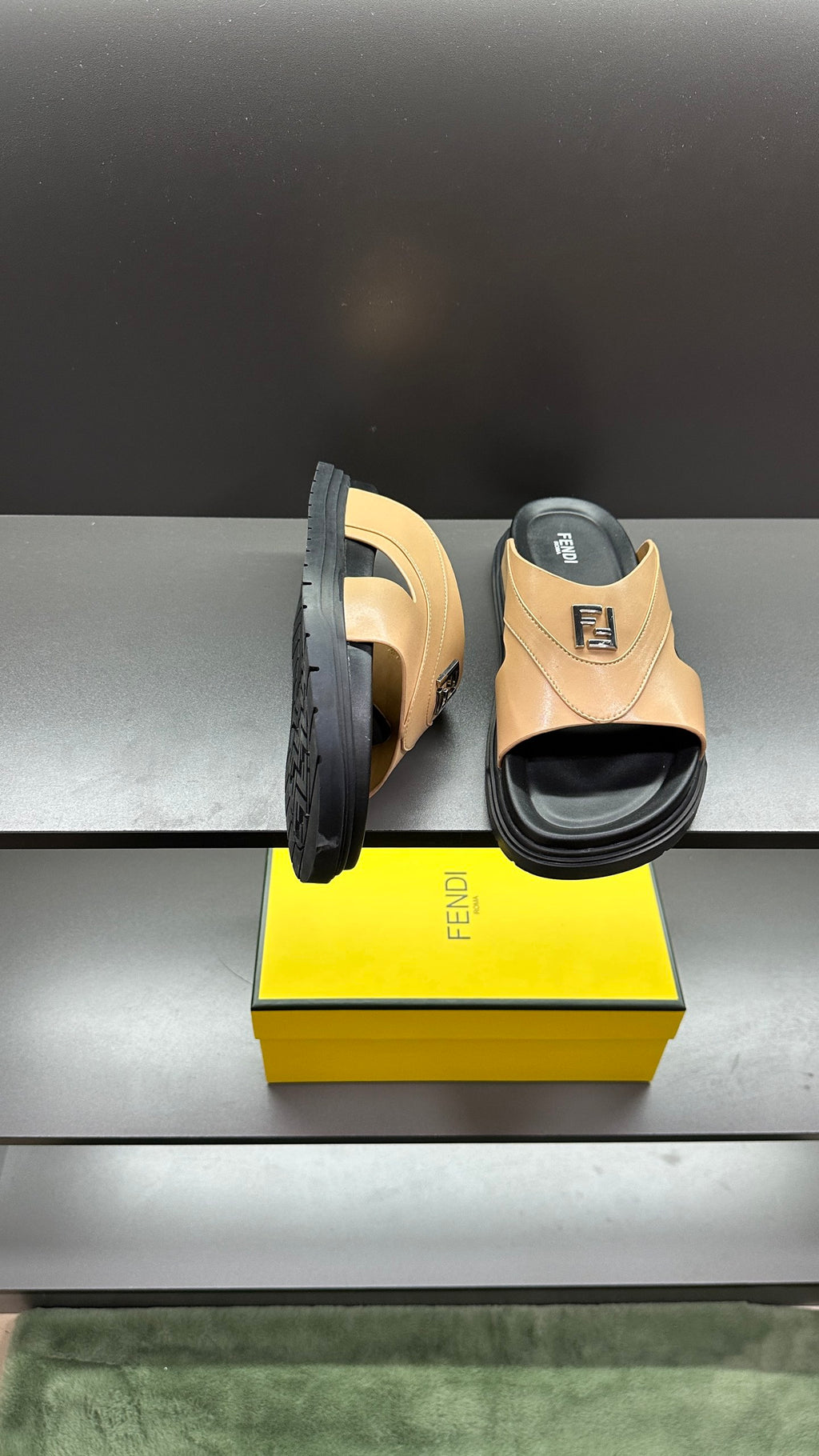 Fendi beige slide sandals with open toe and black sole, side view beside box