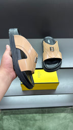 Fendi beige slide sandals from side; thick black sole and F logo on upper
