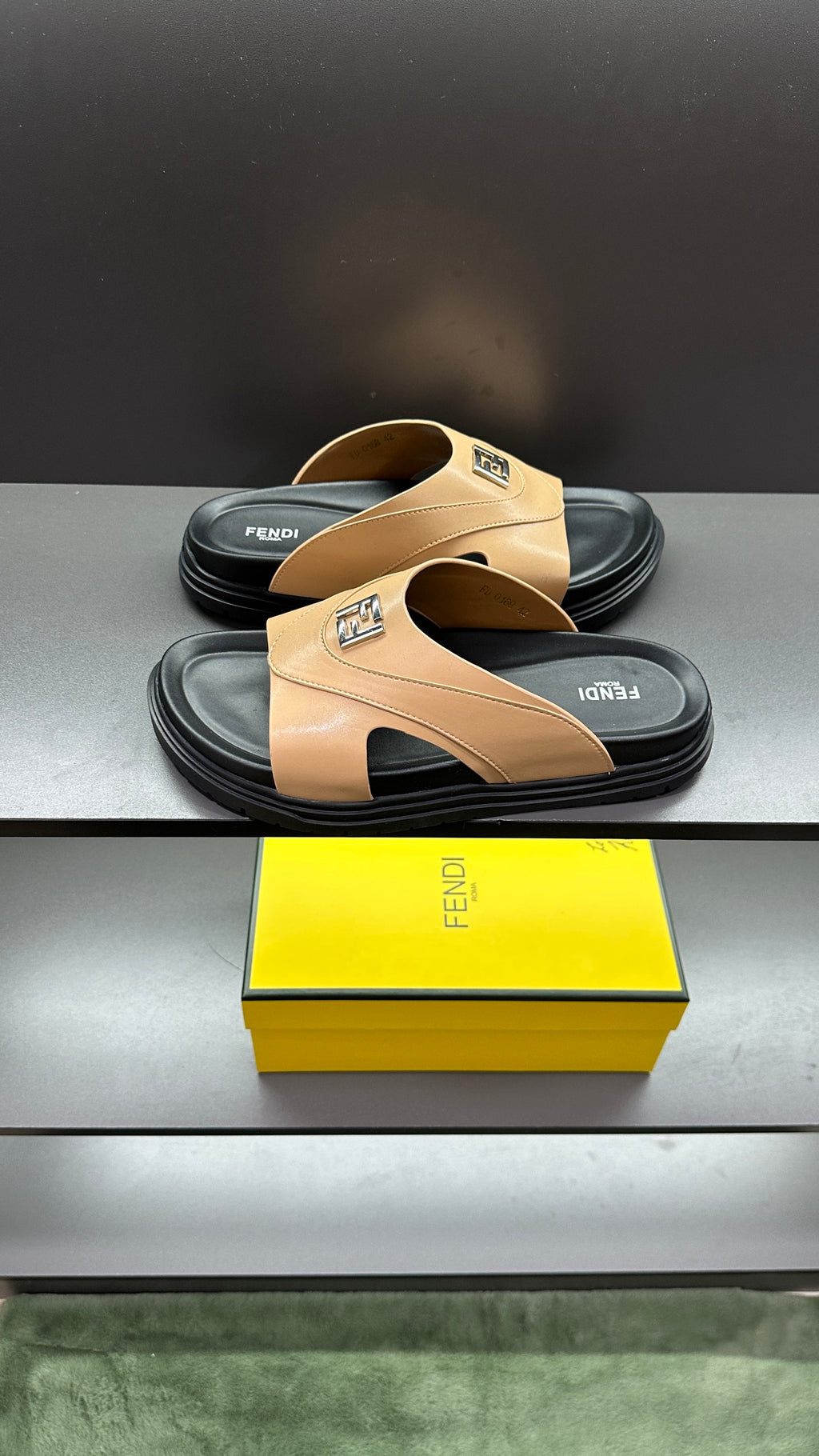 Fendi beige slide sandals with sculpted black outsole edge, shown on box