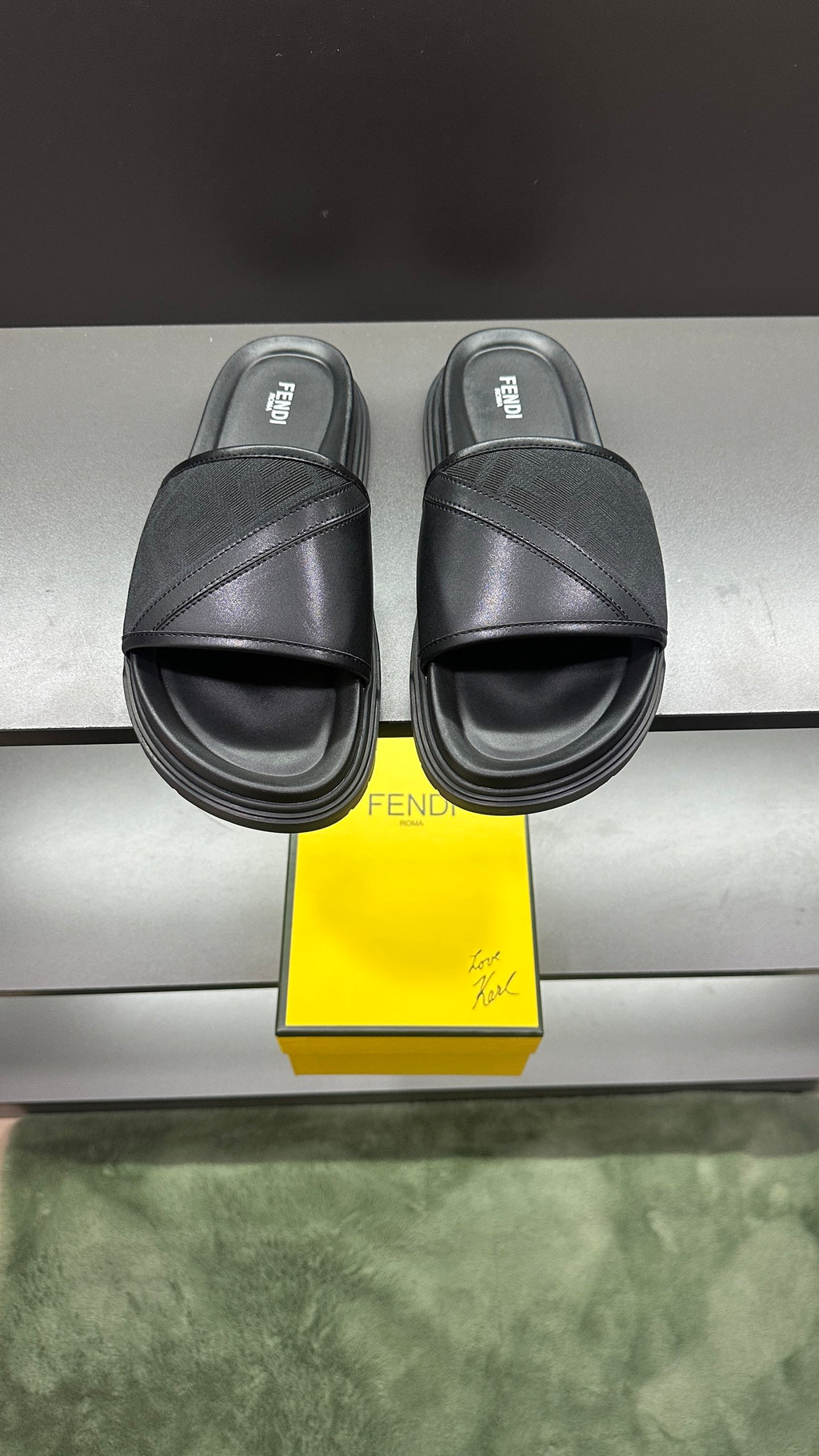 Fendi slide sandals in dark color with wide cross strap and cushioned platform sole