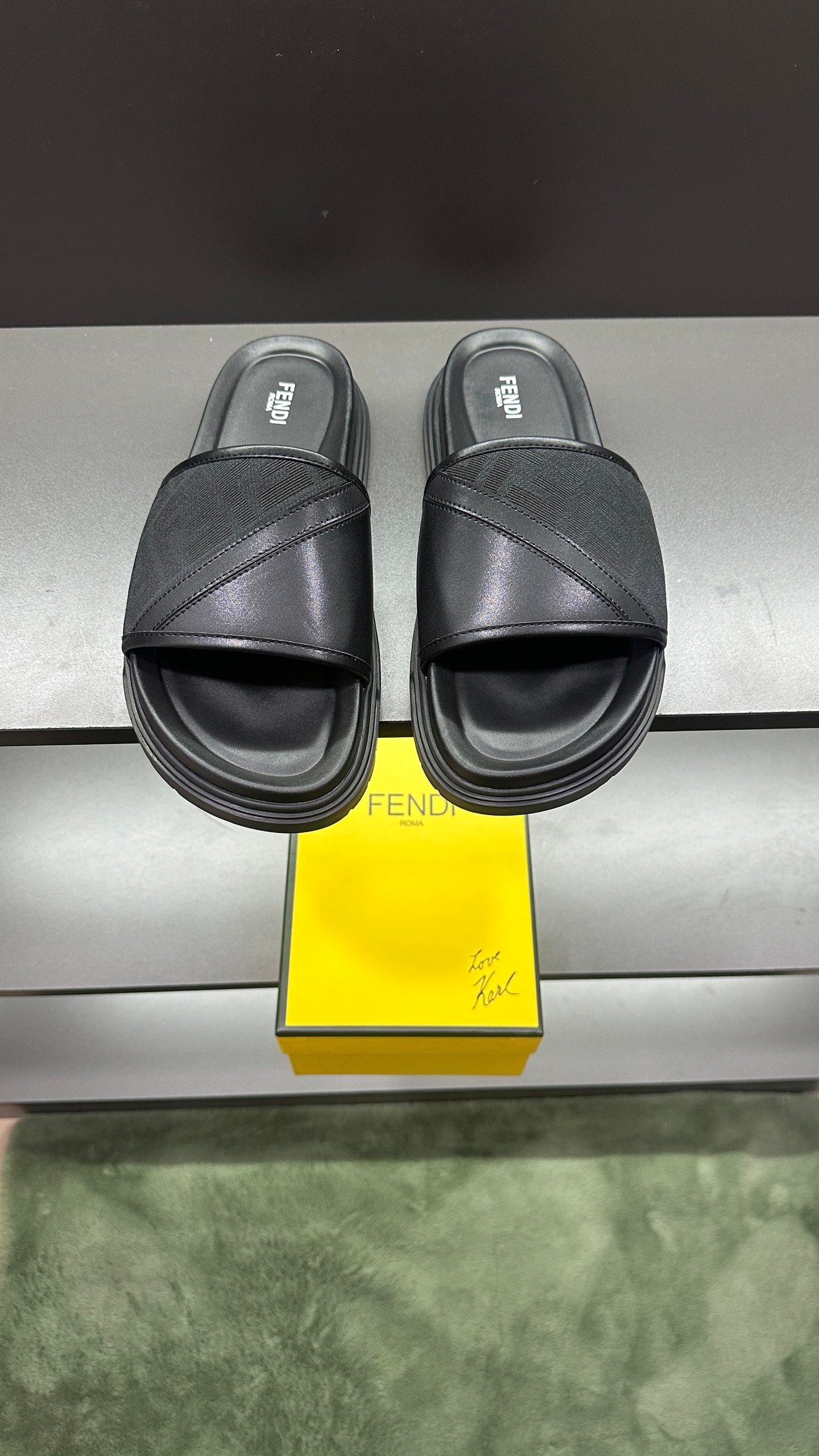 Fendi slide sandals in dark color with wide cross strap and cushioned platform sole