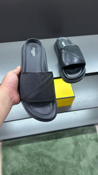 Fendi slide sandals held by hand, dark upper and cushioned platform sole