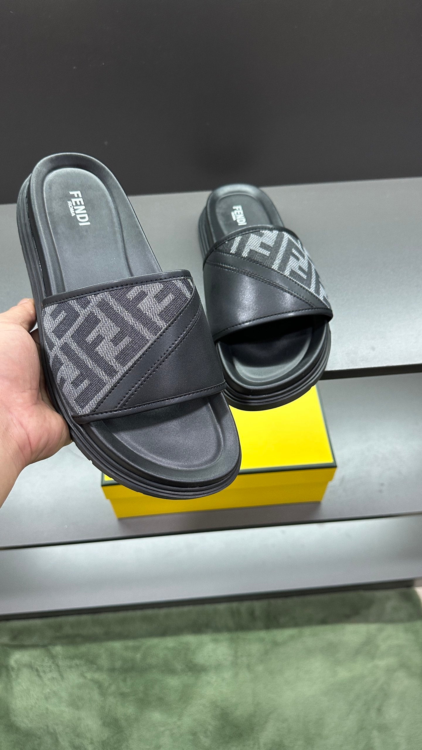 Leather slide sandals with FF logo strap, shown in hand