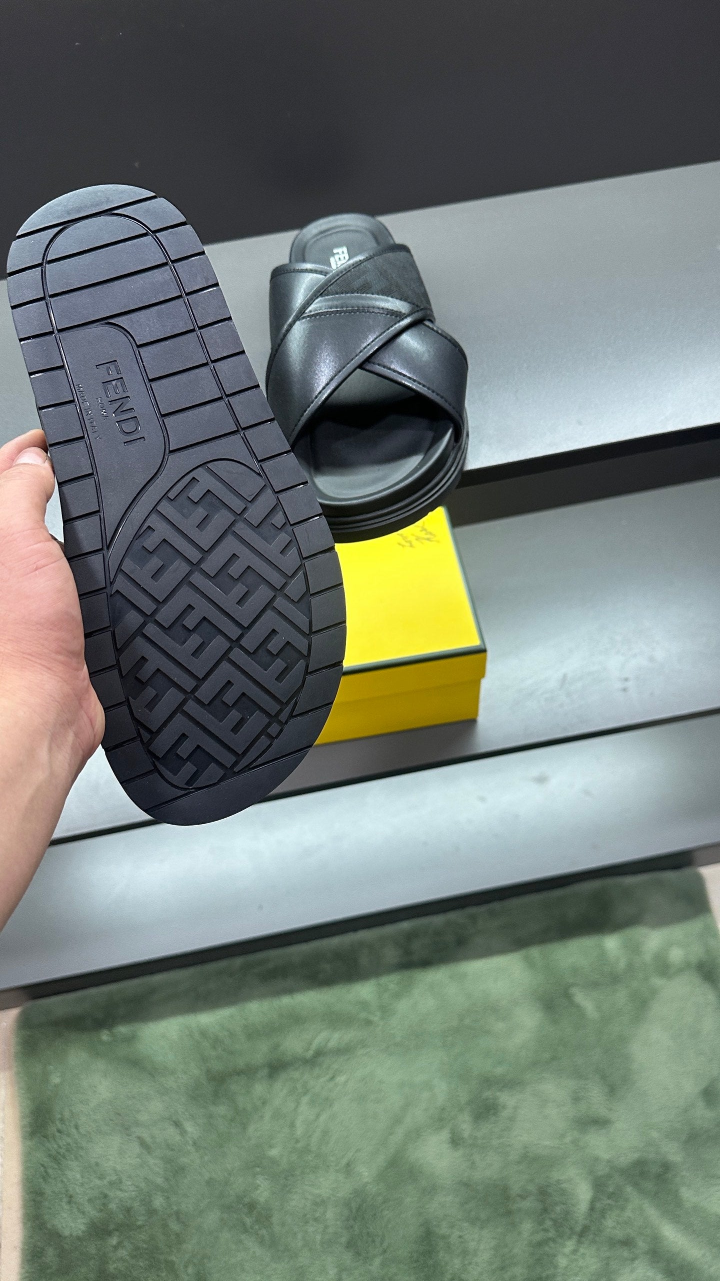 Fendi black slide sandals showing treaded outsole and heel logo