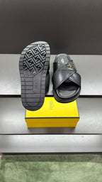 Fendi black slide sandals with treaded outsole facing camera, FF logo strap