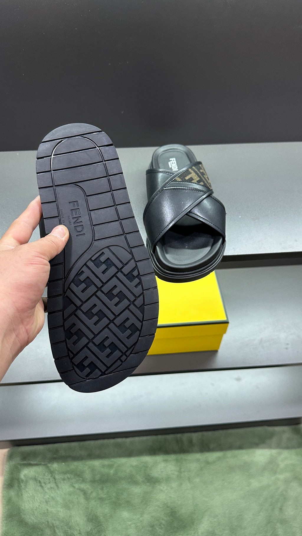 Fendi black slide sandals showing treaded outsole and FF logo strap