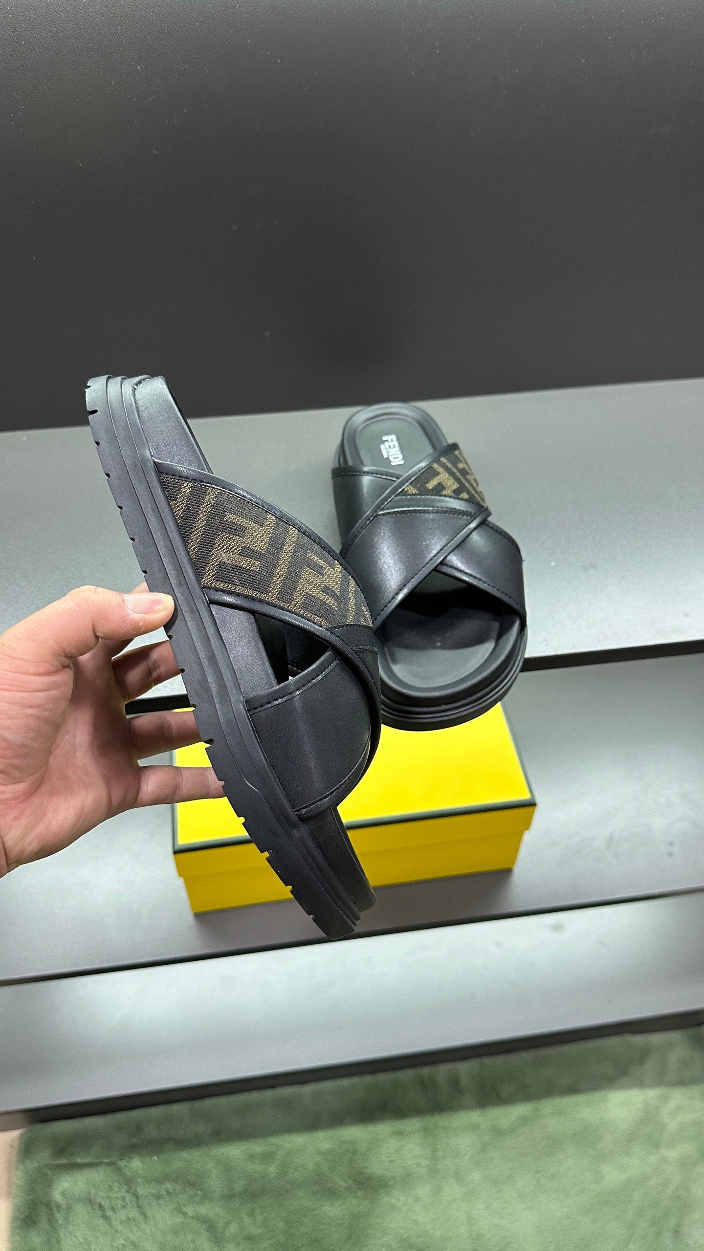 Fendi black slide sandals showing side and sole, FF logo strap
