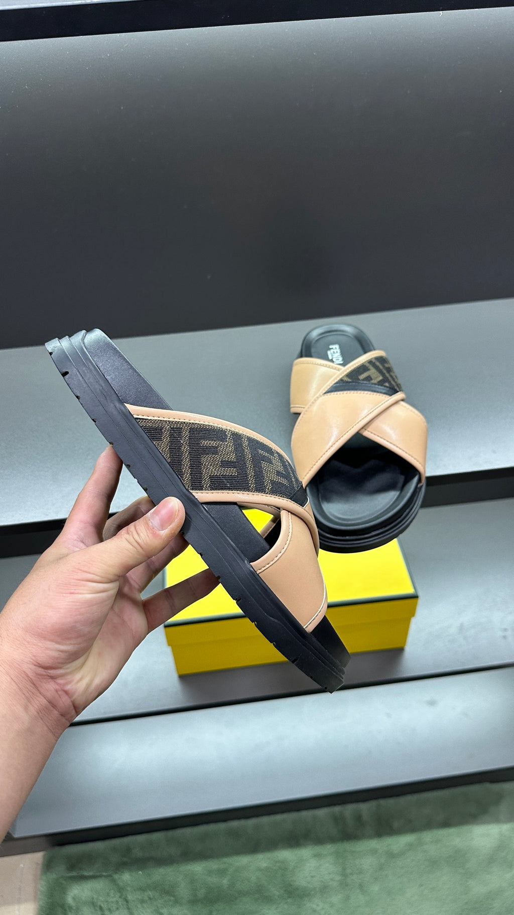 Fendi slide sandals with beige strap and dark logo upper, black rubber sole