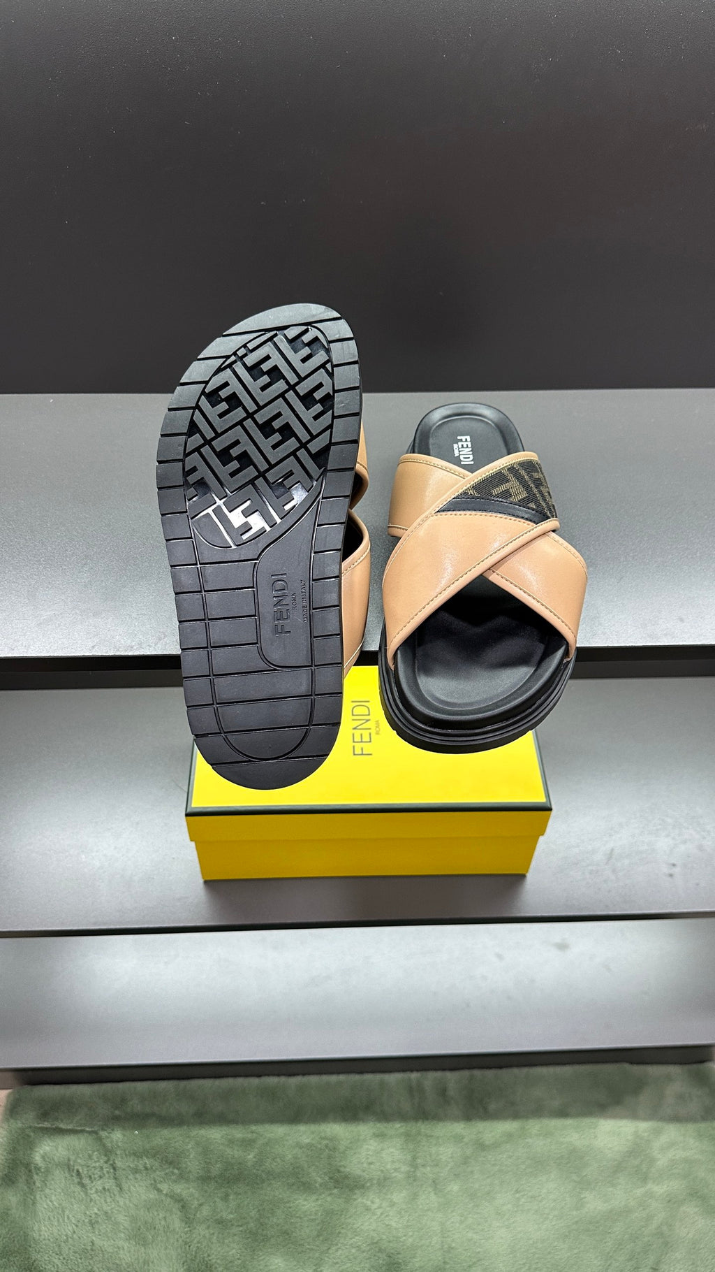 Fendi slide sandals with textured black outsole featuring Fendi logo pattern, beige upper