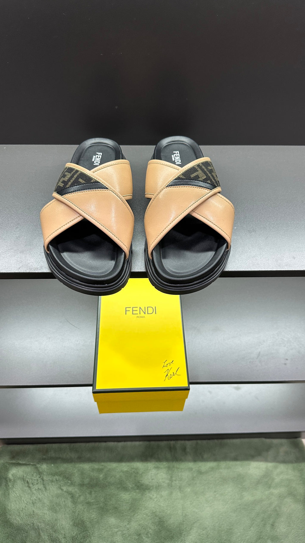Fendi slide sandals with beige crisscross straps, dark logo trim, black sole