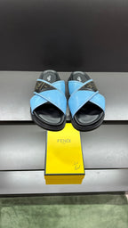 Fendi blue sandals with crisscross straps and dark rubber sole, with Fendi logo detail