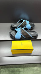 Fendi blue slide sandals with cross straps and dark rubber sole, angled on display