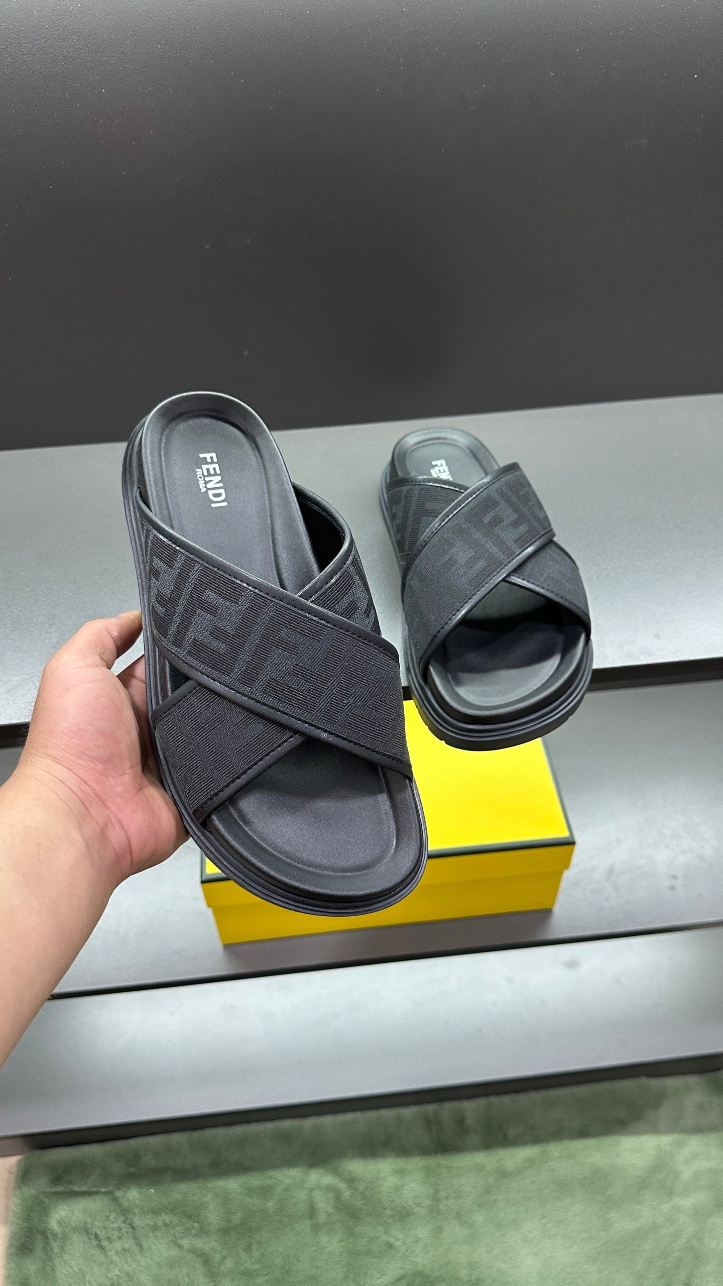 Fendi slide sandal in dark color with FF logo strap and open toe on thick sole