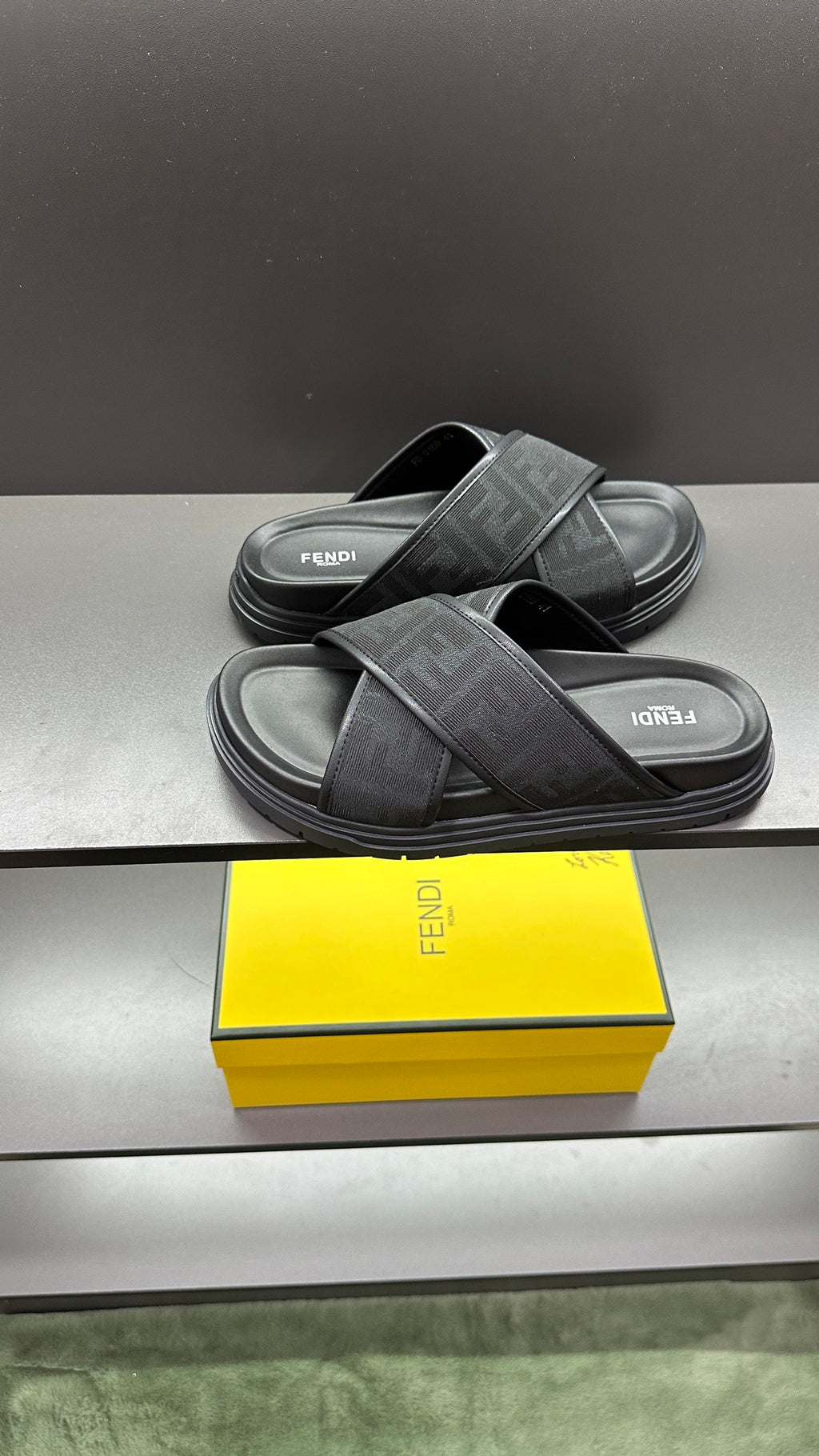 Fendi slide sandals on dark footbeds with crossed FF logo straps and textured soles