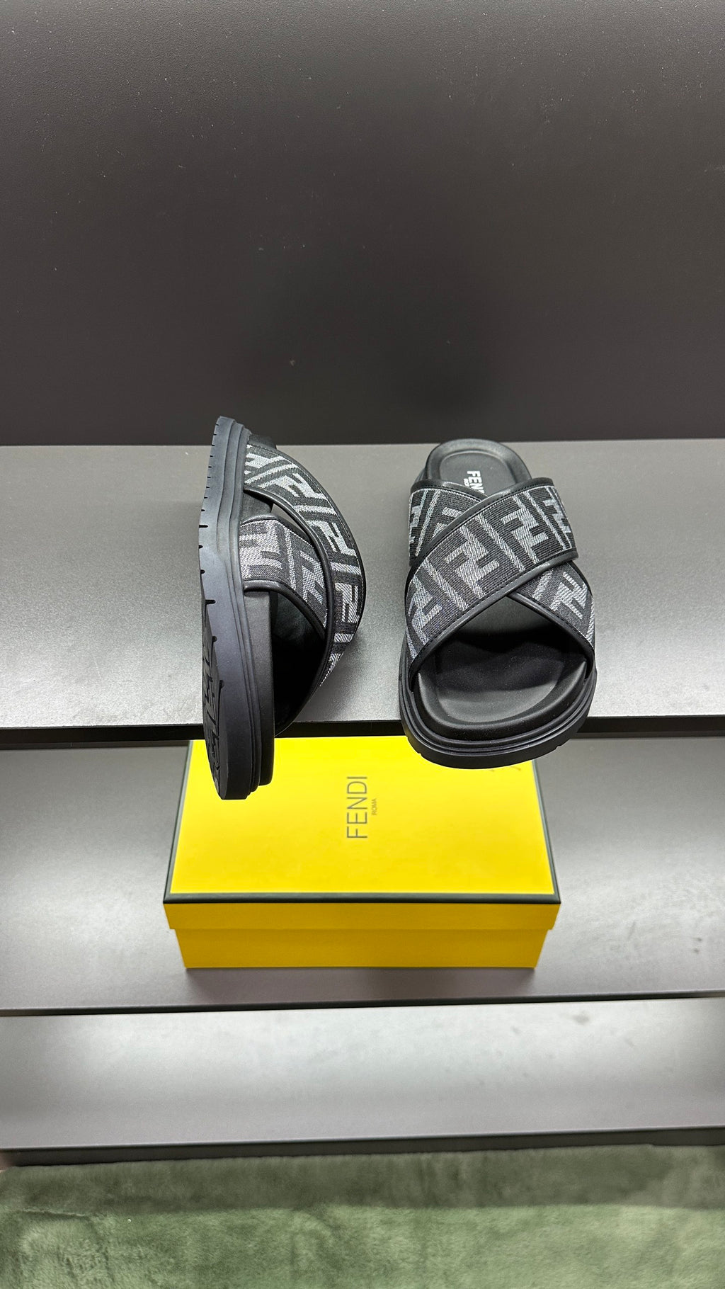 Fendi FF logo slide sandals showing side profile, dark gray straps and chunky dark sole