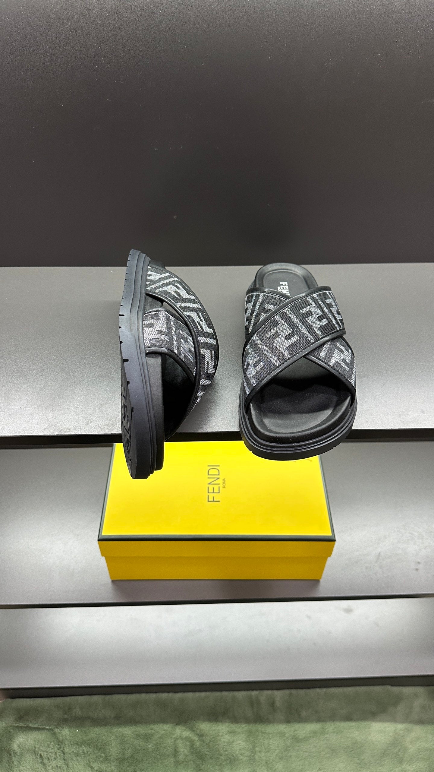 Fendi FF logo slide sandals showing side profile, dark gray straps and chunky dark sole