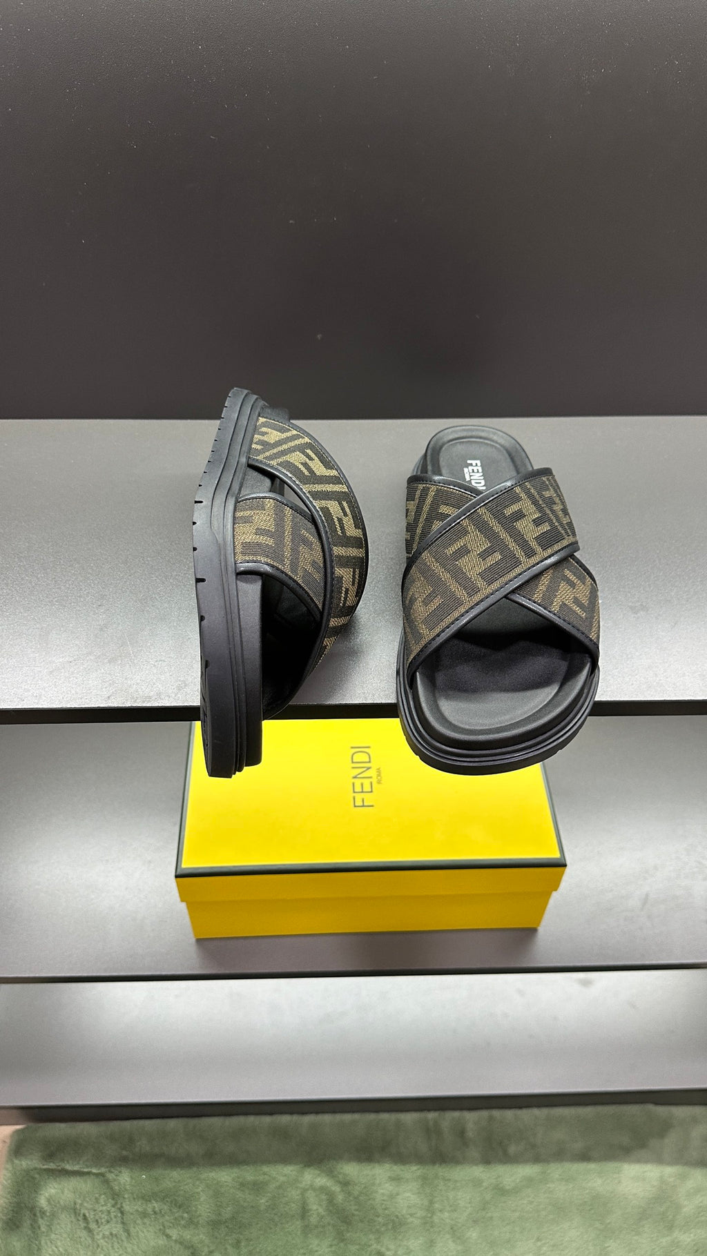 Fendi slide sandals, open side view, FF logo strap over dark footbed