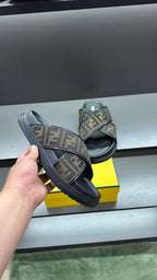 Fendi slide sandals held up, dark sole and FF logo strap with wide band
