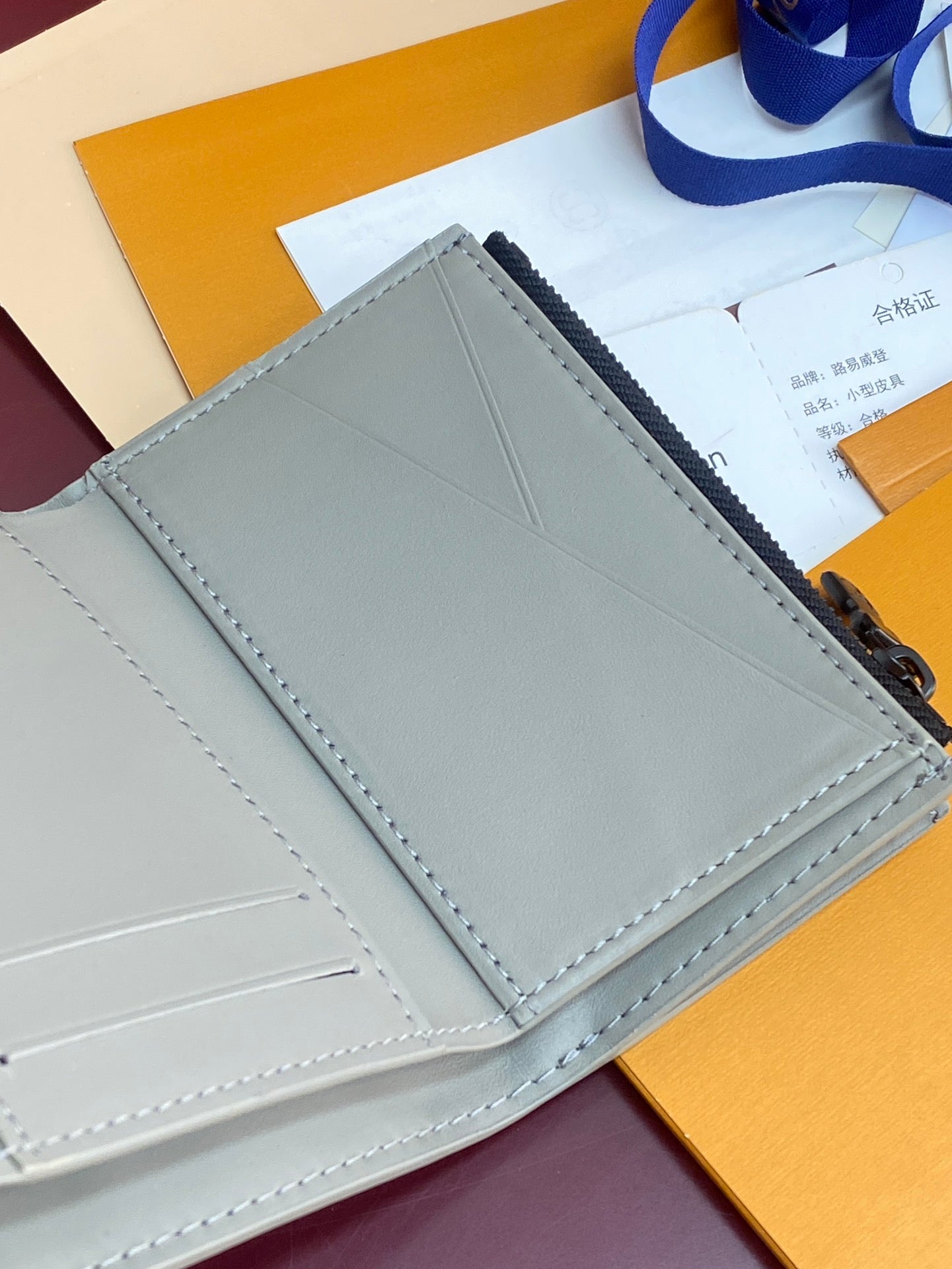 Small bag open view showing light gray interior panel and stitched seams.
