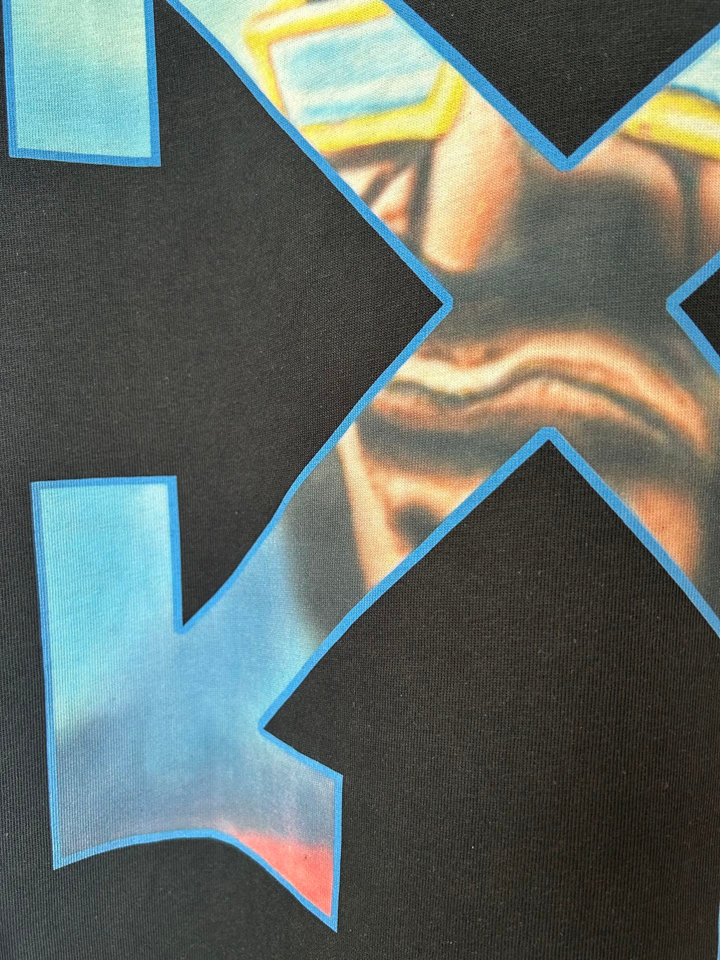 Close-up of multicolor arrow X print on dark T-shirt fabric