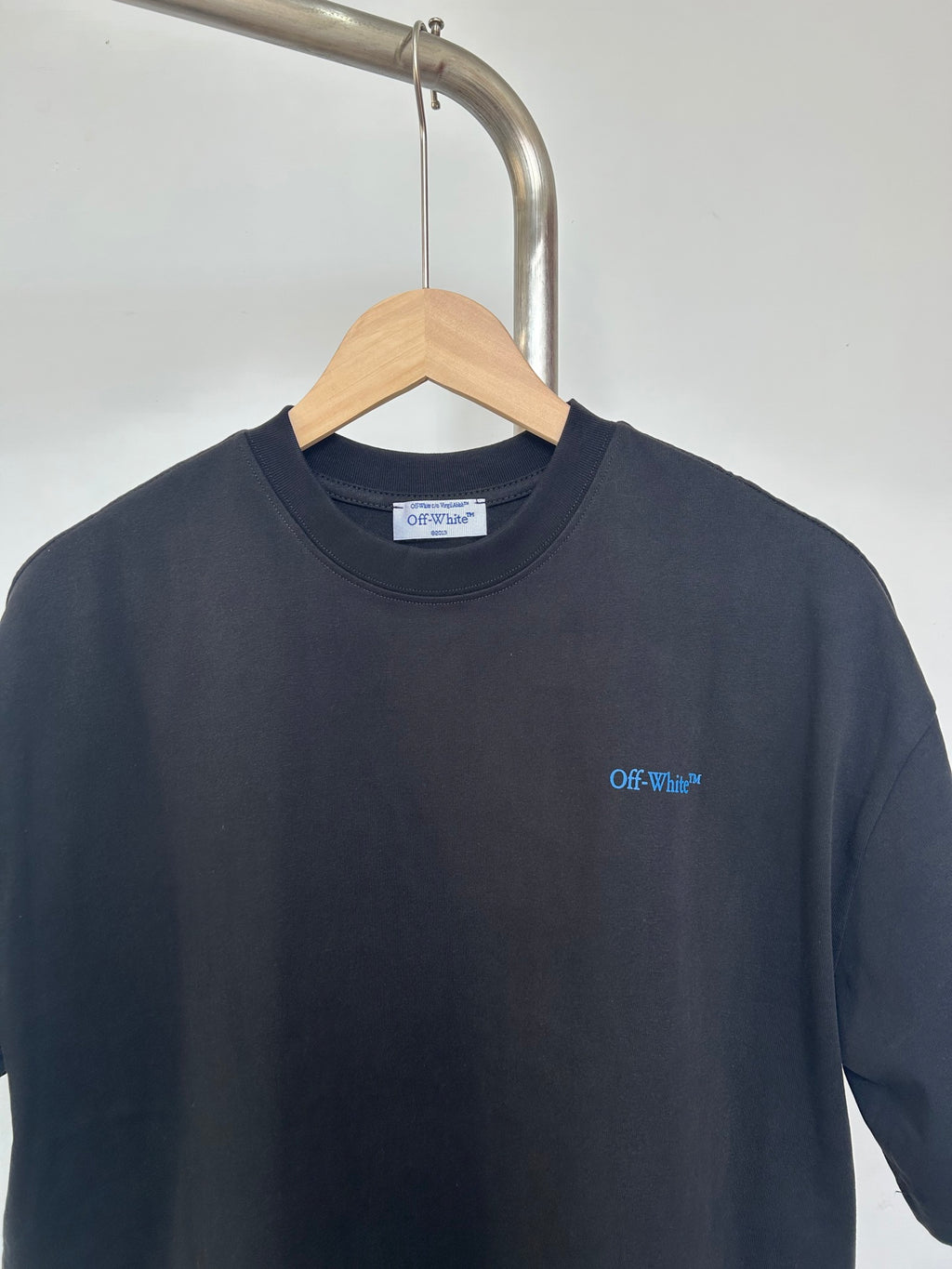 Dark T-shirt neckline with small Off-White chest logo print
