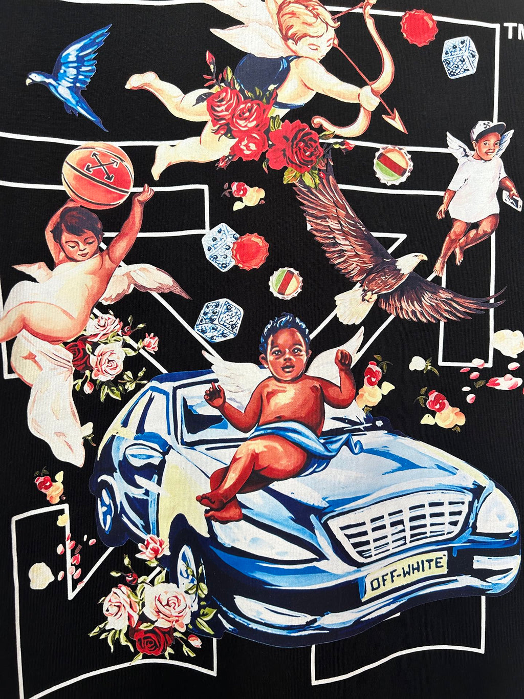 Black T-shirt close-up: car and angel-like figures with roses graphic