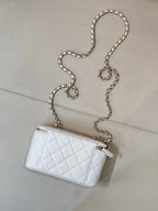 Chanel white quilted mini bag with chain strap, zip top, CC logo detail.