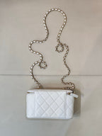 Chanel white quilted mini bag with chain strap and zip top, gold-toned hardware.