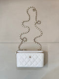 Chanel white quilted bag with diamond pattern, chain strap, zip top, CC logo.