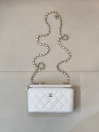 Chanel white quilted bag with diamond pattern, chain strap, zip top, CC logo.