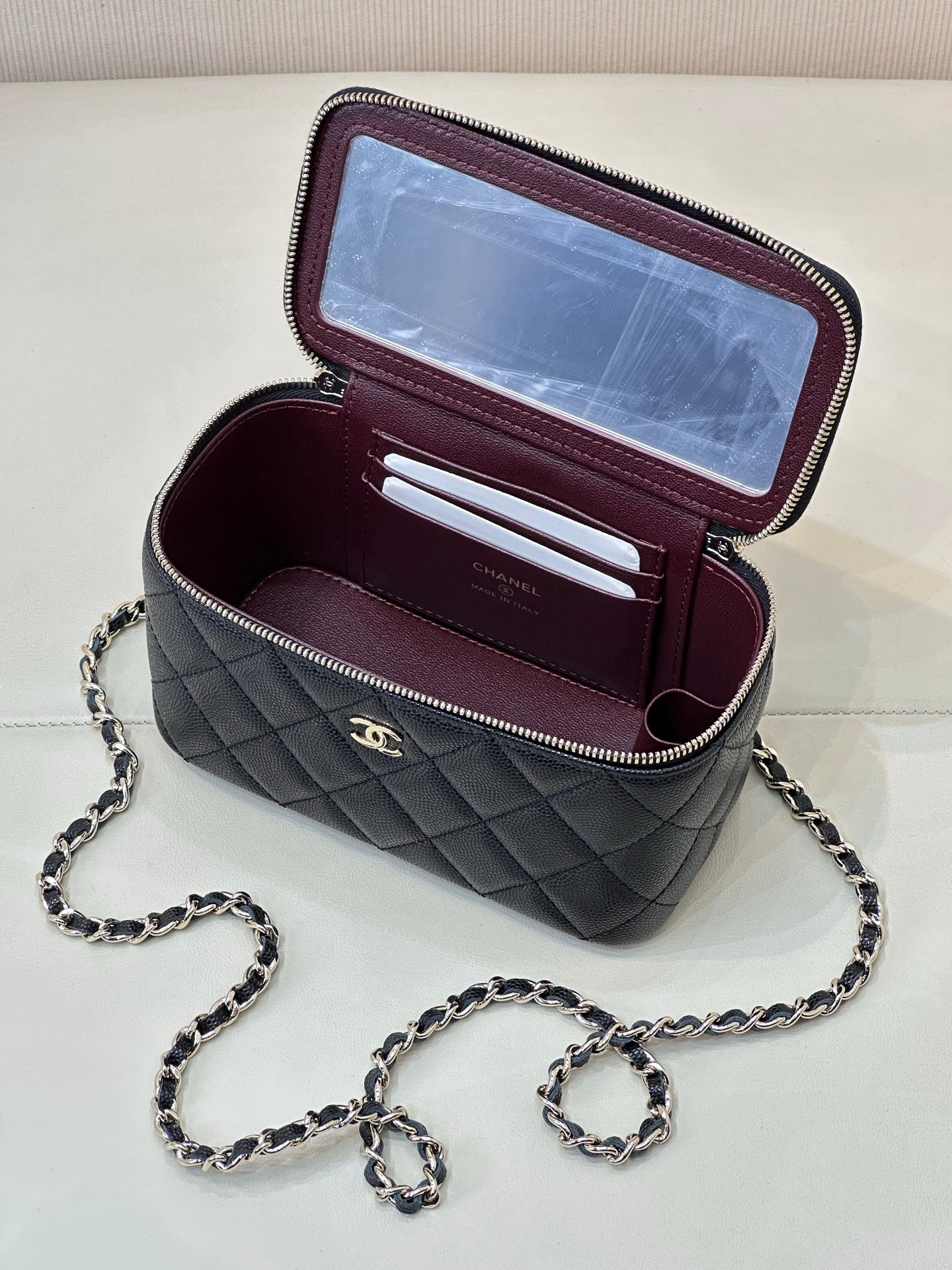 Chanel quilted mini bag open, dark navy exterior with burgundy card slots