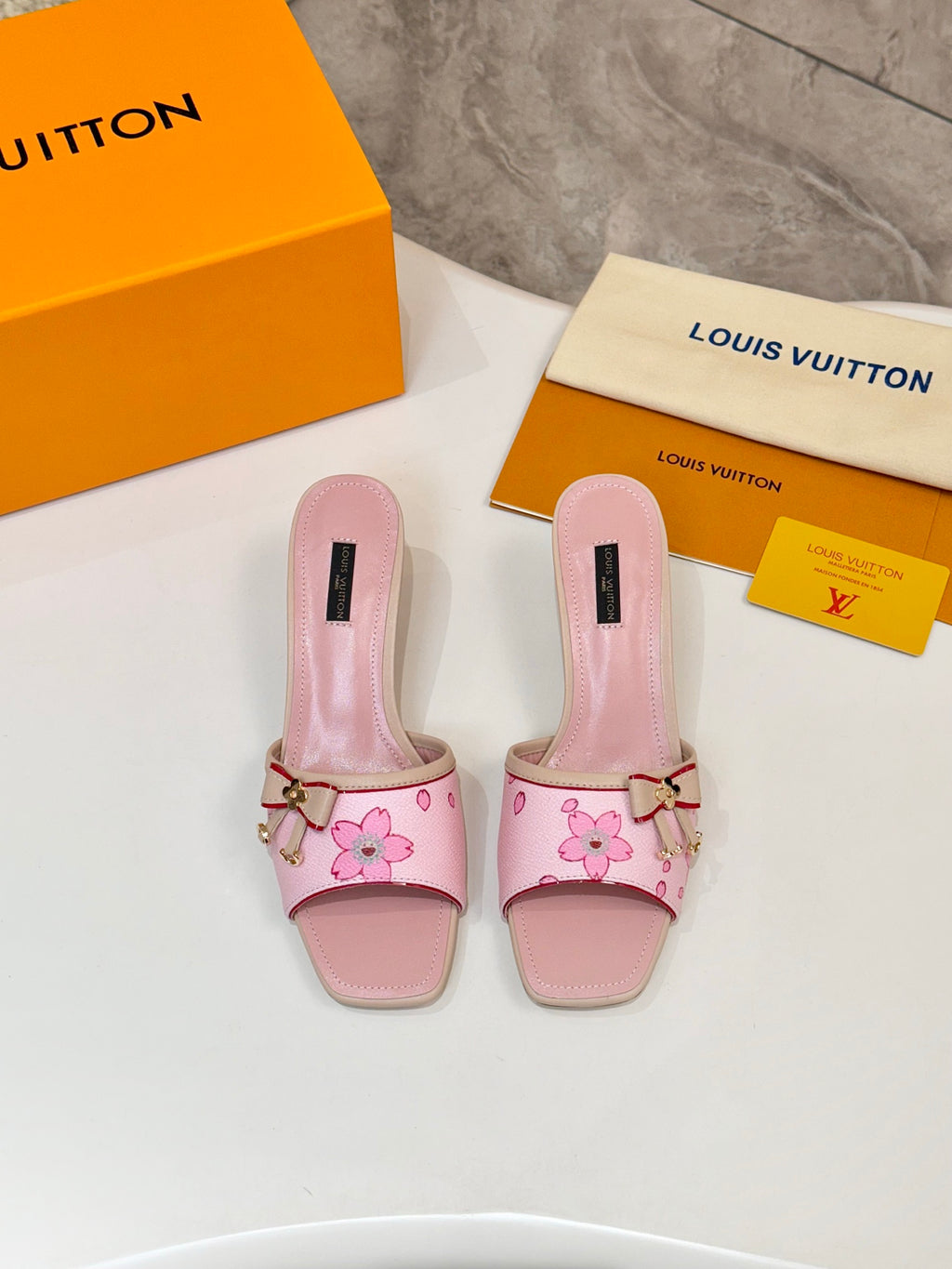Pair of pink Louis Vuitton ladies mules with flower print, buckle strap, block heel