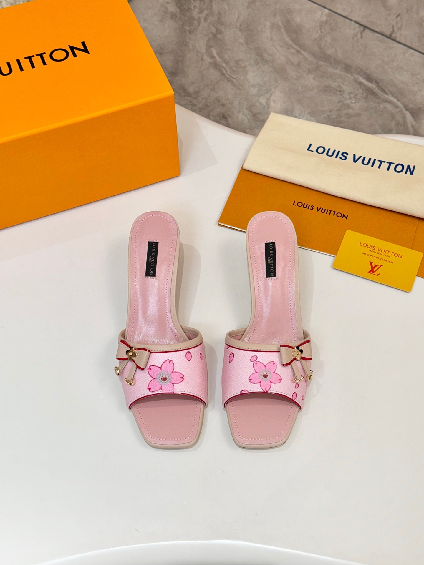 Pair of pink Louis Vuitton ladies mules with flower print, buckle strap, block heel