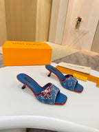 Louis Vuitton ladies blue monogram slide mules with red trim, shown on white surface