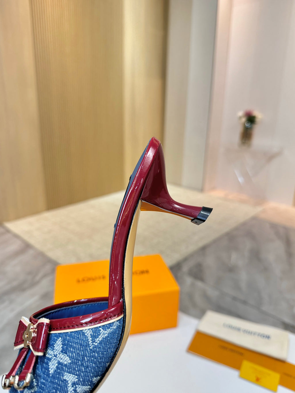 Louis Vuitton ladies blue monogram slide mule with red strap, buckle and bow hardware, side view