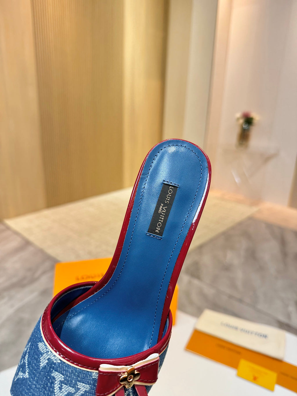 Louis Vuitton ladies blue monogram slide mule with red trim and buckle bow, angled close-up