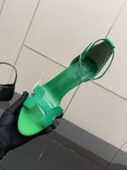 Hermes ladies green heeled sandal held near toe, showing T-strap detail