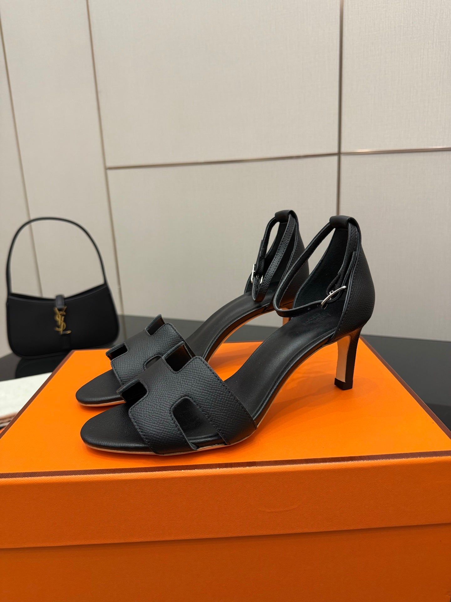 Black leather heeled sandals with cross-over straps, square toe, and thin stiletto heel