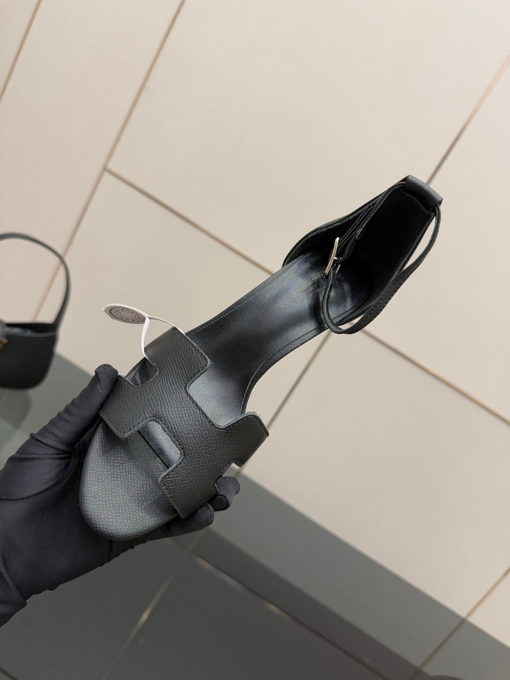 Black leather heeled mule sandal with textured strap detail and slim stiletto heel