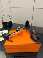 Black leather heeled mule sandals with square toe, cutout straps, and cushioned footbed