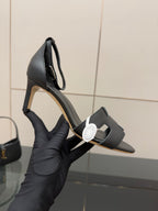 Black leather heeled mule sandals with square toe and adjustable strap, close-up