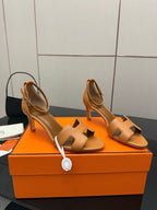 Tan leather heeled sandals with cutout straps and buckle detail, side view