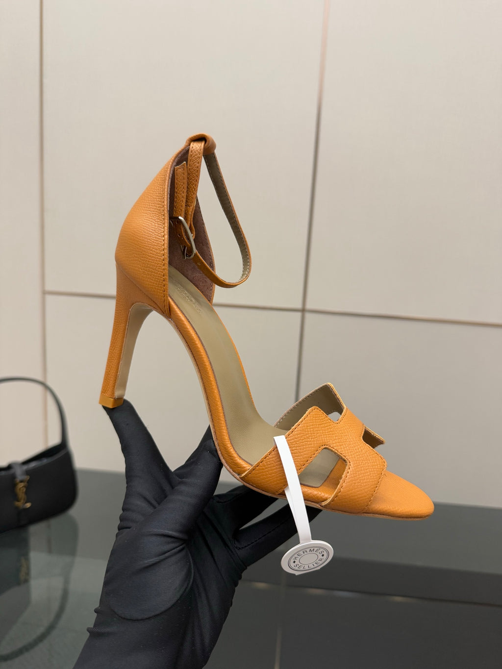Hermes tan leather heeled sandal for ladies, open toe with ankle strap, held in hand