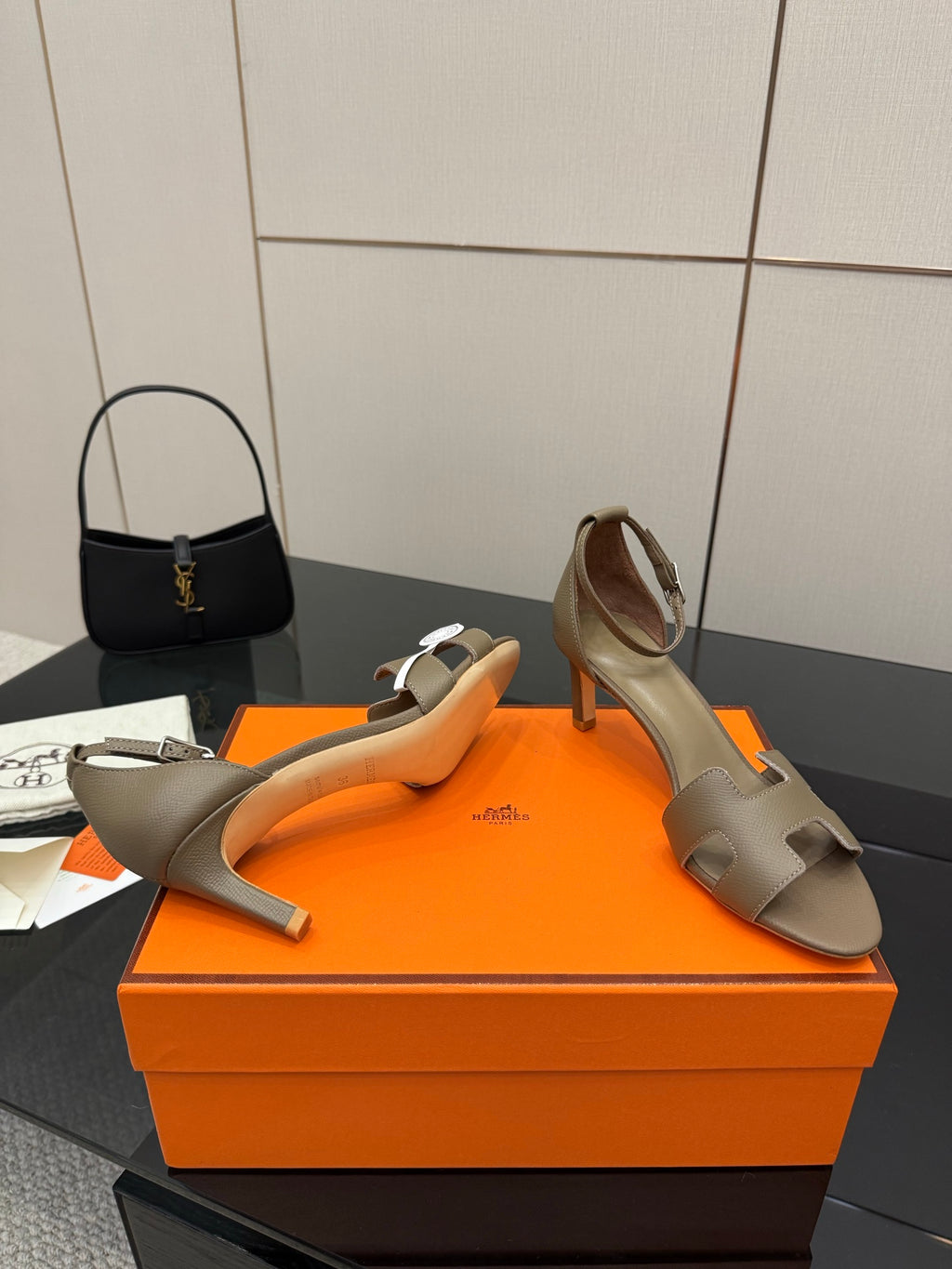 Light gray heeled sandal with open toe, ankle strap, and slim block heel.