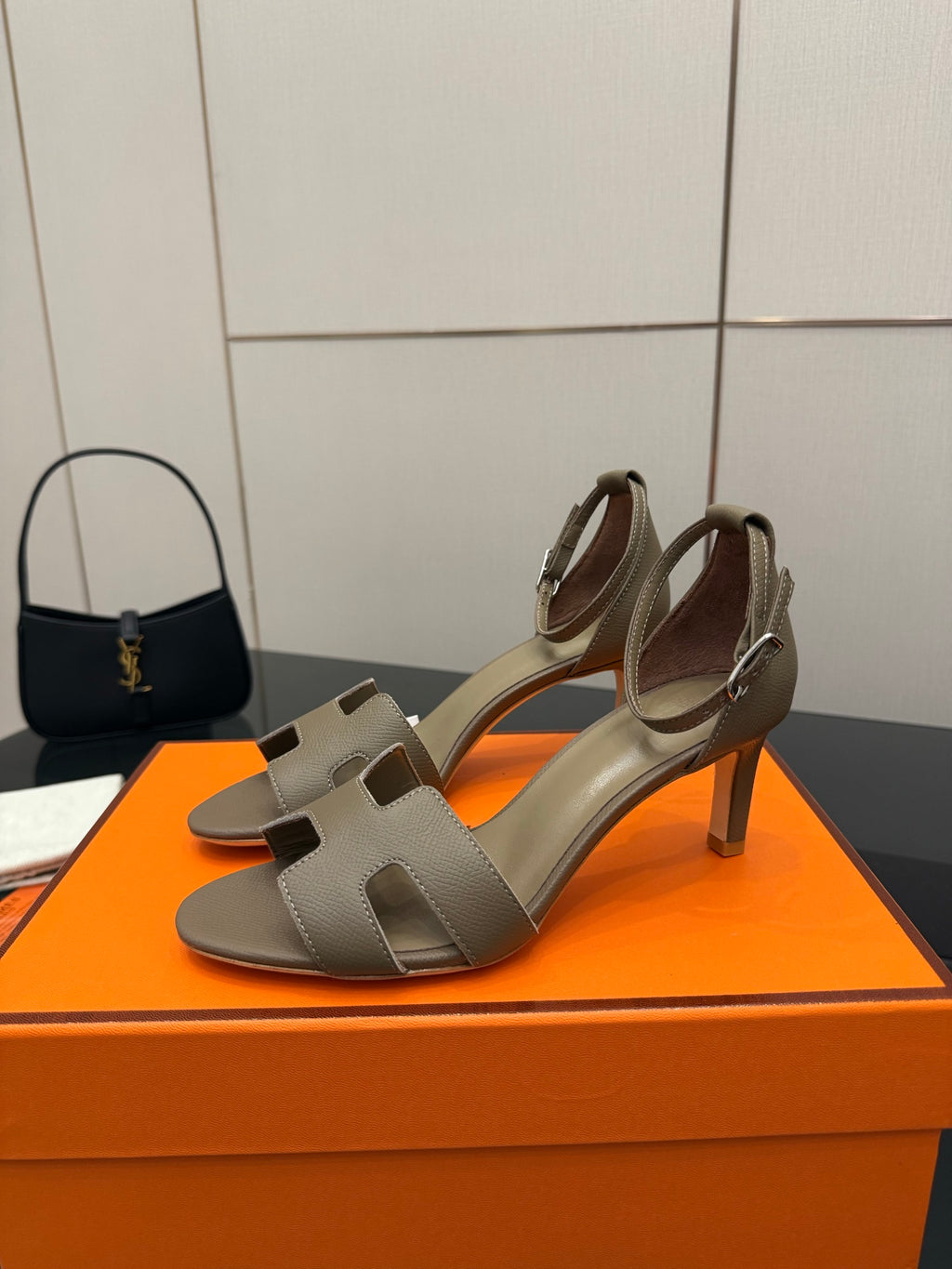 Light gray heeled sandal with ankle strap, open toe, and block heel.