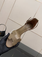 Light gray heeled sandal with open toe and ankle strap, shown from the side.